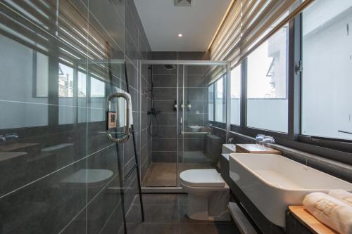 a bathroom with a sink and a toilet and a shower at JIDMI HOTEL in Xiamen
