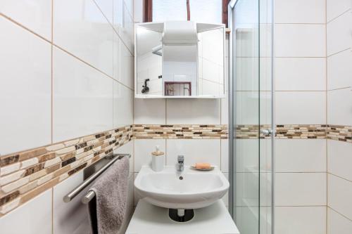 a white bathroom with a sink and a shower at Haus Tannenberg in Todtnau