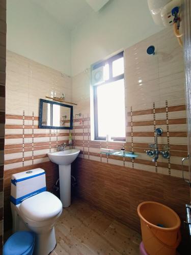 a bathroom with a toilet and a sink at Hotel Bhagirathi in Tehri-Garhwāl