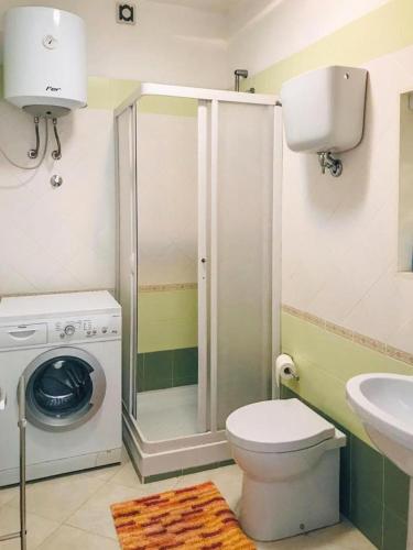 a bathroom with a toilet and a washing machine at Casa Onde Chiare - Pizzo Beach Club 16G in Fondaco Vecchio