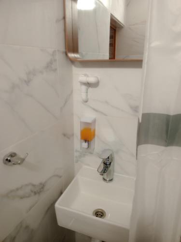 a white bathroom with a sink and a mirror at Christos in Asvestokhórion