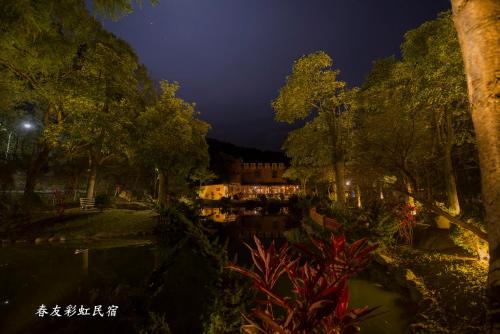 a park at night with a pond and trees at Rainbow SpringYU B&B in Nanzhuang