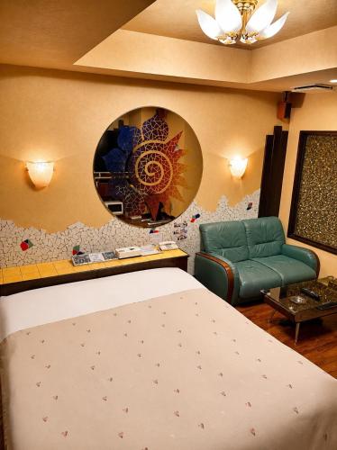 a room with a bed and a chair and a mirror at 名古屋北区のホテルコアラ in Tsujichō