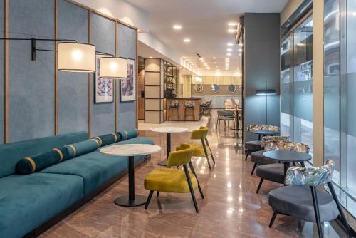 a lobby with a couch and tables and chairs at Hotel Elche Centro, Affiliated by Meliá in Elche