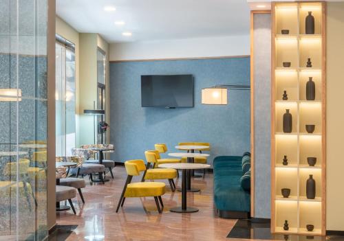 a dining room with tables and yellow chairs at Hotel Elche Centro, Affiliated by Meliá in Elche
