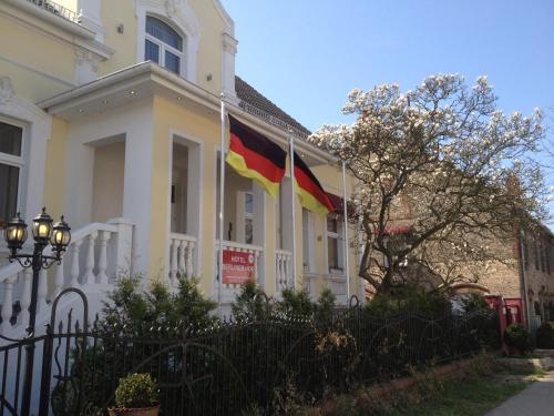 a house with two flags on the side of it at Berliner Hof in Dallgow