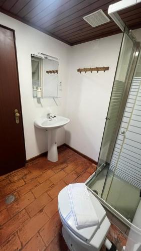 a bathroom with a toilet and a sink at Bungalow Refúgio do Pezo T1 in Melgaço