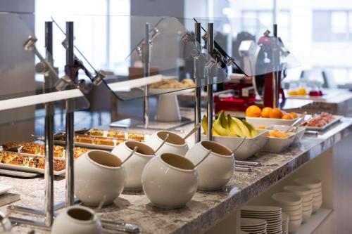 a buffet line with breakfast foods and fruit on at AC Hotel by Marriott Cincinnati at The Banks in Cincinnati