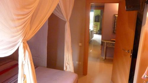サロウにあるApartamento Ones Playa Meroのベッドルーム1室(カーテン付きのベッド1台付)、廊下が備わります。