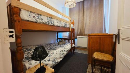 a bedroom with two bunk beds and a lamp at Domaine Les Tourelles - Gîte 2 in Caffiers