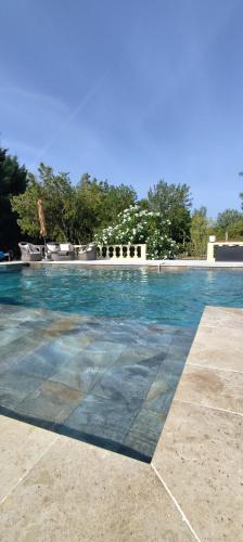 a swimming pool with blue water in a resort at Gîte Maelga in Cartelègue