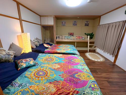 a bedroom with two beds and a crib at NOA - Vacation STAY 80085v in Shikyū