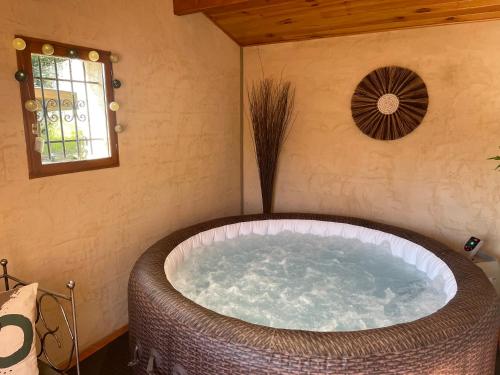 a large bath tub in a room with a window at La Chambre Haute, spa et jardin extérieur à Nîmes in Nîmes
