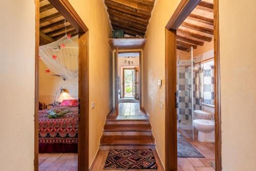a hallway of a home with a bed and a bathroom at Paradis Oasis Santa Maria in Chiusdino