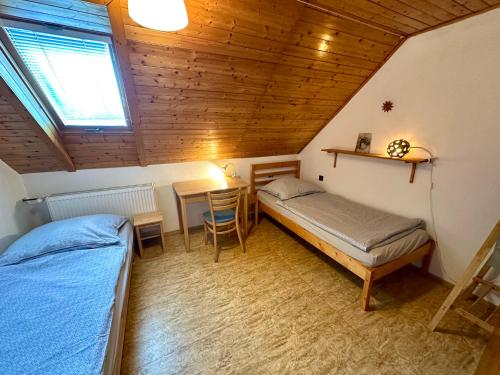a bedroom with two beds and a table in a attic at Ubytko Ivko in Letohrad