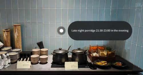 a kitchen counter with pots and pans on a stove at Atour Hotel Shanghai Caohejing in Shanghai