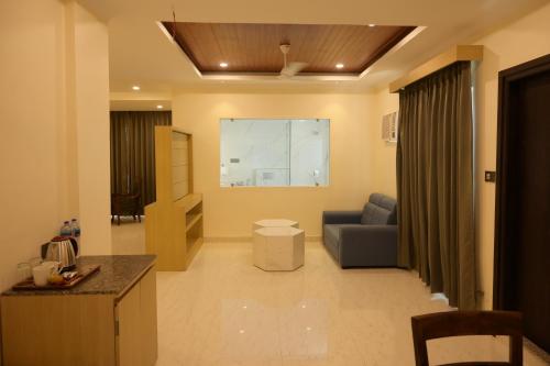 a living room with a couch and a chair in a room at Hotel Grand Mayfair in Dimapur