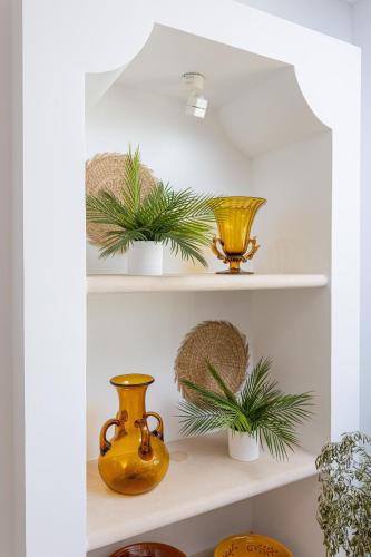 a shelf with vases and palm plants on it at SOL by Meliá Cala d'Or Apartamentos in Cala d´Or