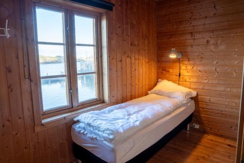 a small bed in a room with a window at Authentic rorbu by the sea in Stamsund