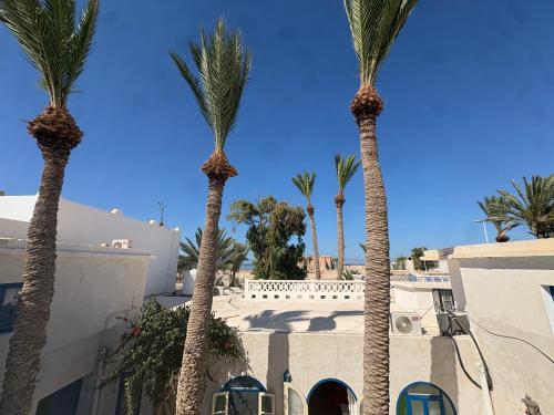 a group of palm trees in front of a building at CoZi at Dar Faiza in Houmt Souk