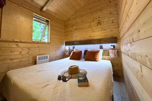 a bedroom with a bed with a hat and sunglasses on it at Camping la Source in Thérondels