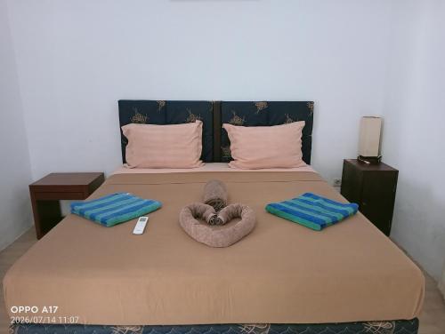 a bed with two animal towels on top of it at Ani Bungalows in Gili Trawangan