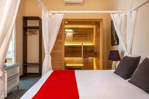 a bedroom with a white bed with a red blanket at Snob Luxury Suite in Cagliari