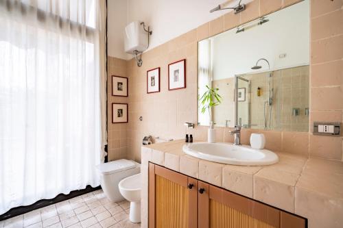a bathroom with a sink and a toilet and a mirror at Snob Luxury Suite in Cagliari