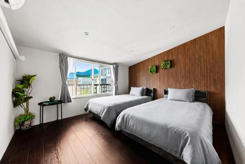 a bedroom with two beds and a window at VIOLET GARDEN - Vacation STAY 37201v in Furano