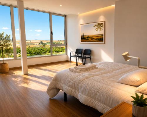 a bedroom with a large bed and large windows at Bodega Díscolo in Zamora