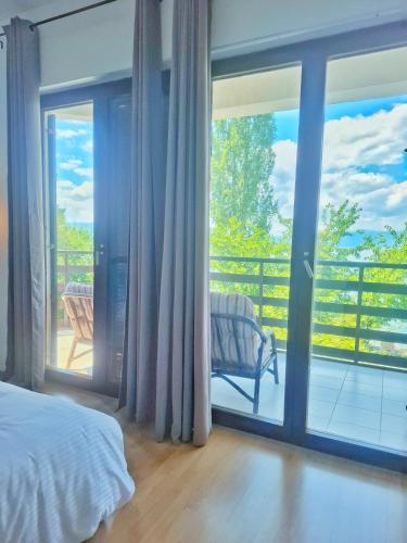 a bedroom with a bed and a view of a balcony at Villa Boris- Next to the Beach with Parking in Ohrid