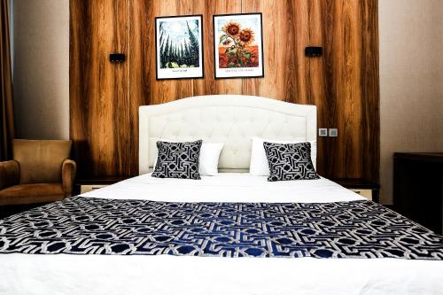 a bedroom with a white bed with three pictures on the wall at Family Resort Hotel in Selimpasa