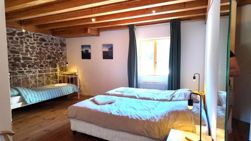 a bedroom with a bed and a stone wall at Domaine de Bellac - Le Triangle in Roussines