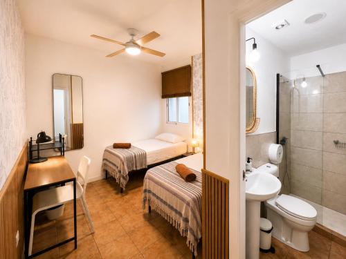 a bathroom with two beds and a sink and a toilet at Kite & Surf Nomad House in Las Palmas de Gran Canaria