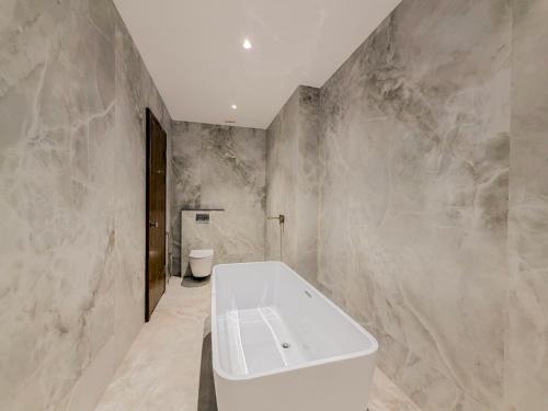 a bathroom with a white tub and a toilet at Jain Tree by Spree Hotels Vellore in Vellore