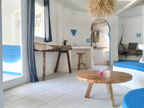 a living room with a table and a kitchen at SHAYA cottage in Sekotong