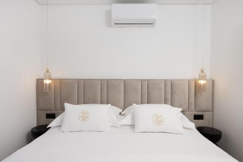 a bedroom with a white bed with two white pillows at Villa Perla Vir in Vir