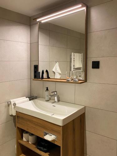 a bathroom with a sink and a mirror at Das Allgäu in Maierhöfen