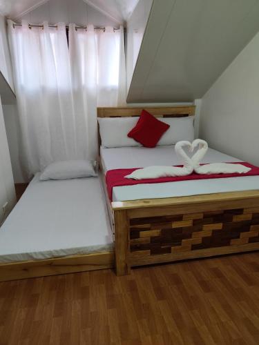 two beds in a small room with white curtains at Balancia Guest House 3F unit 5 in Baguio