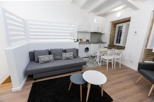 a living room with a couch and a table at Apartamentos Pombal in Santiago de Compostela