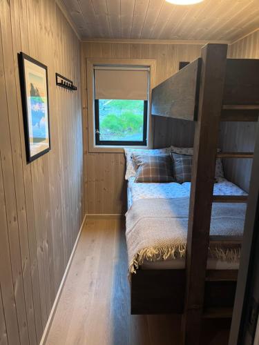 a small room with a bunk bed and a window at Lofoten Arctic Cabin in Sørvågen