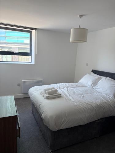 a white bedroom with a bed and a window at Broadway residence G01 in Bradford