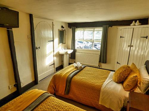 a hotel room with two beds and a sink at Ye Olde Red Horse in Evesham