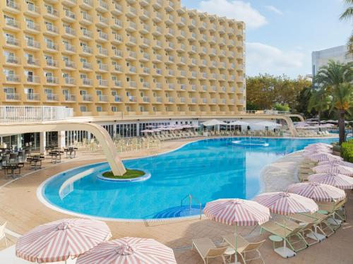 a large hotel with a swimming pool with umbrellas at SOL by Meliá Guadalupe in Magaluf