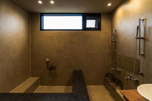 a bathroom with a shower and a sink and a window at 목포 미유스위트 호텔 in Taeban-dong