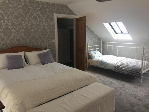 a bedroom with two beds and a skylight at Roomz in Portaferry