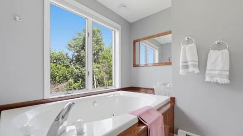 a white bathroom with a tub and a window at Fox Lair by AvantStay in North Creek