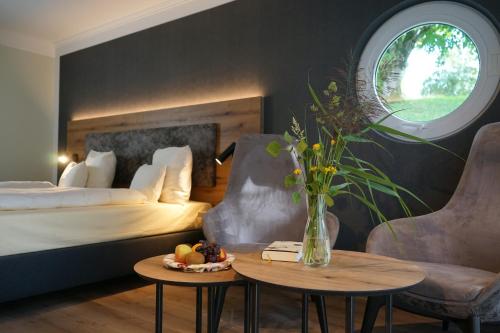 a hotel room with a bed and a table with a vase of flowers at Das Allgäu in Maierhöfen