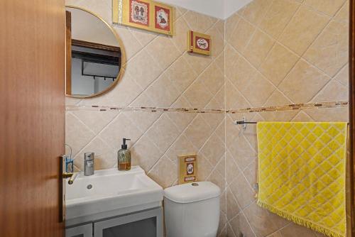 a bathroom with a sink and a toilet and a mirror at Azeitão Town House in Azeitao
