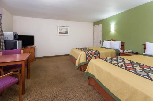 a hotel room with two beds and a television at Knights Inn Franklin Ave Waco in Waco